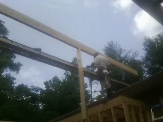 Carpenter setting a ridge beam over a new addition frame — Ice Dam Removal by Roofing Brothers in Powell Butte